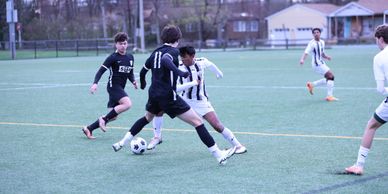 Youth soccer players competing for the ball on a green field.