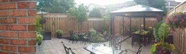 A cozy backyard patio with wrought iron furniture and a gazebo.
