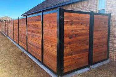 Modern wooden fence with black metal frame enclosing a backyard.