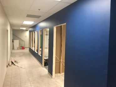 Hallway under construction with blue walls and unfinished door frames.