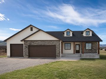 Modern suburban house with three-car garage and stone accents.