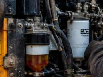 Close-up of a machine's hydraulic or fuel filtration system with hoses and filters.