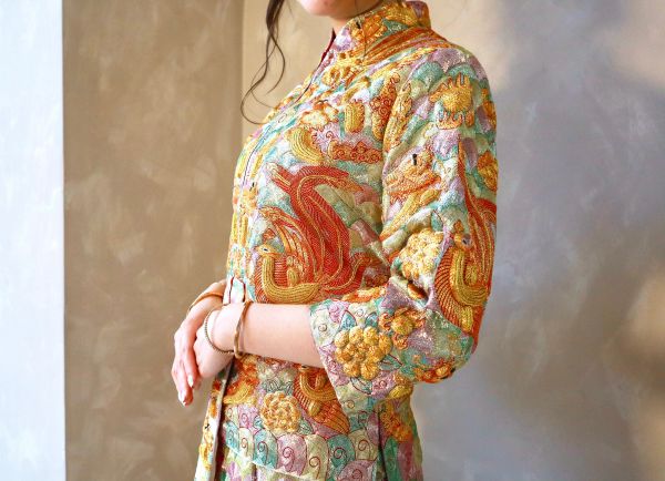 Woman wearing a colorful traditional embroidered dress.