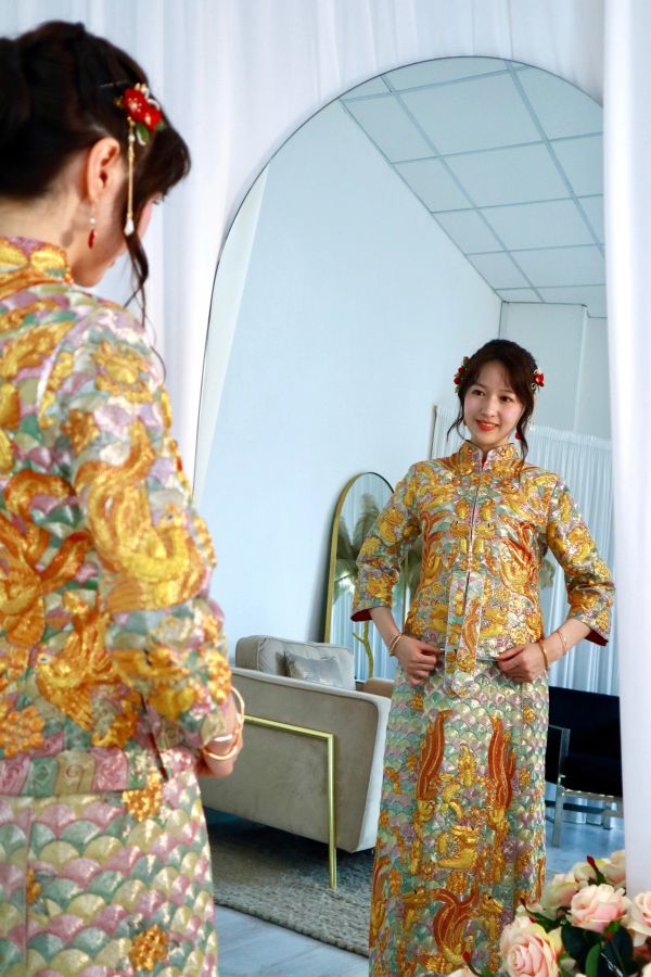 Woman in traditional dress looking in mirror.