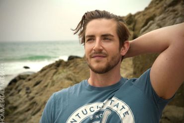 Man relaxing by the beach with a thoughtful expression.