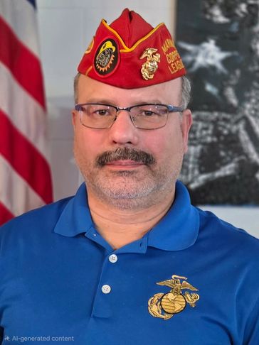 Man wearing a Marine Corps League hat and polo shirt with emblem.