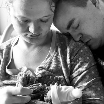 Parents lovingly hold their newborn in a tender moment.