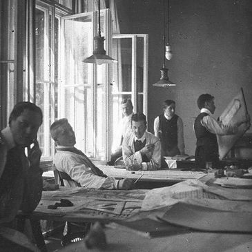 Mies, Gropius, and others working hard in Peter Berhens office.