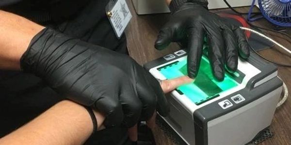Person taking a fingerprint scan using a biometric device.
