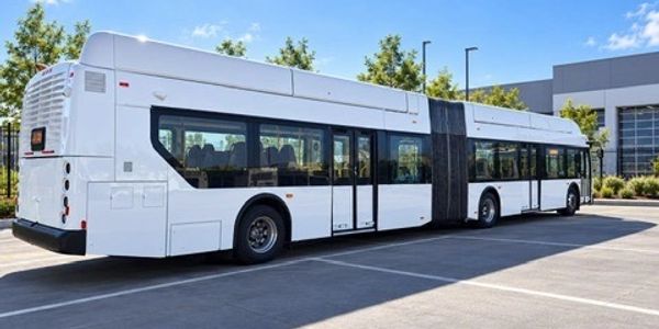 White articulated city bus parked outside.