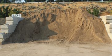 Large pile of sand between concrete blocks labeled Black 18.