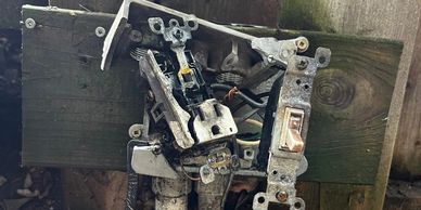 Broken and damaged electrical outlet and switch on a wooden board.