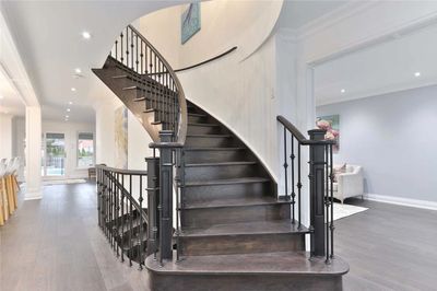 spiral stair case finished in white oak stained dark gray with black iron balusters in stone harbor 