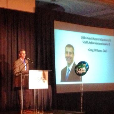Man delivering an award acceptance speech on stage.