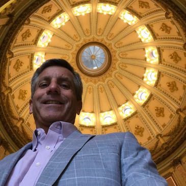 Man smiling under a decorative dome ceiling.