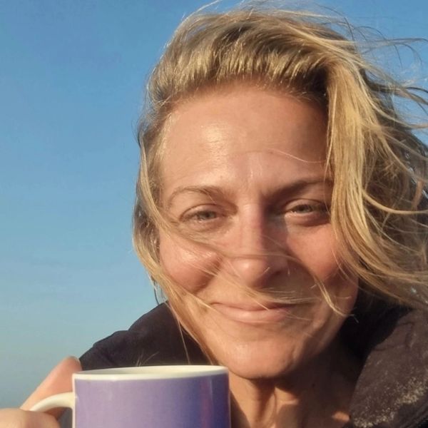 Image of Madeleine smiling drinking tea.