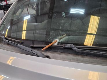Car windshield damaged by a rod.
