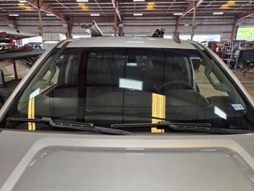 View of a vehicle windshield inside a garage or workshop.