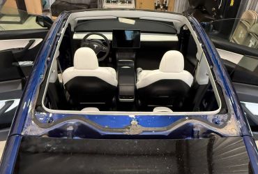 Interior view of a Tesla car from above, showing seats and dashboard.