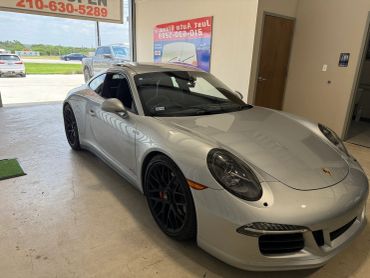 Silver Porsche sports car in a showroom.