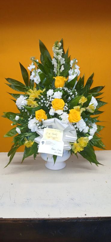 Yellow and white flower arrangement with green leaves