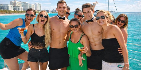Group of friends enjoying a sunny boat party with drinks and smiles.