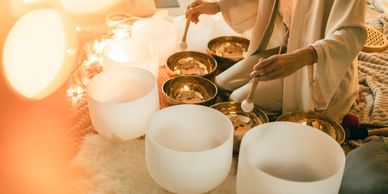 Person playing crystal singing bowls for sound therapy.