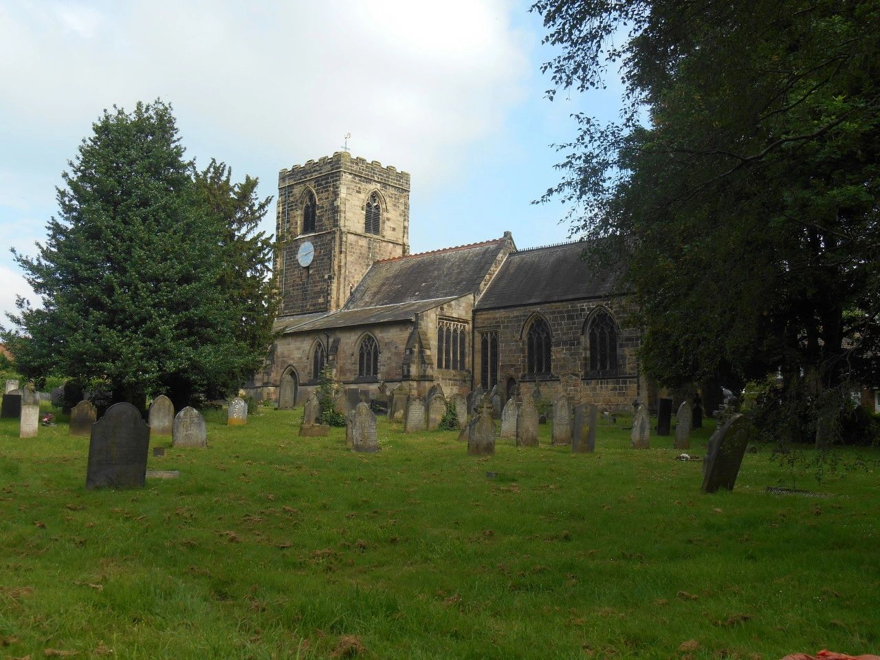 Old stone church surrounded by gravestones.