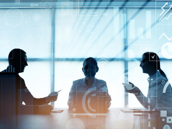 Double exposure of virtual screen and colleagues at business meeting in office
