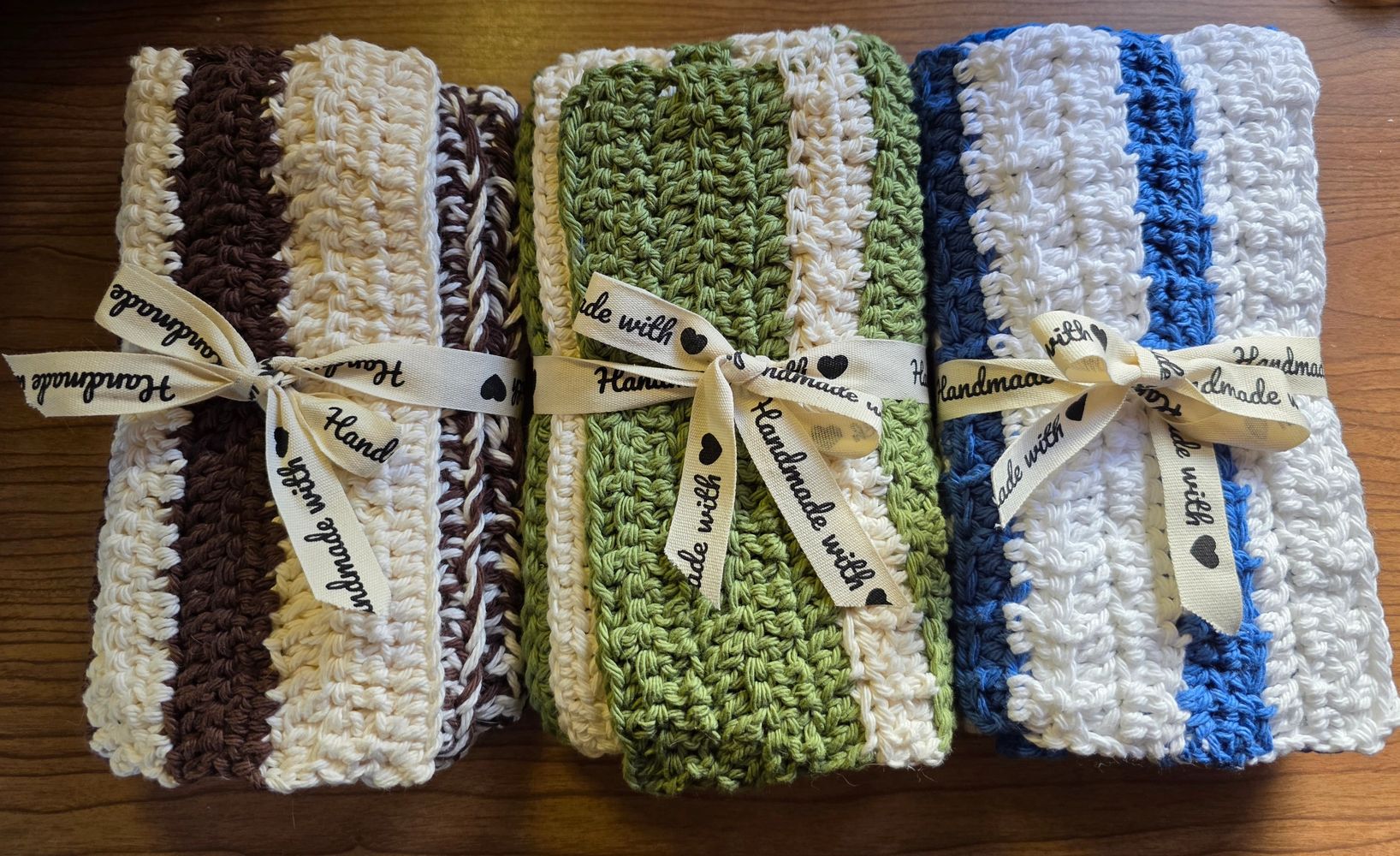 Three sets of striped handmade crocheted towels tied with "Handmade" ribbons.