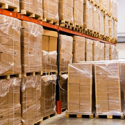 Warehouse stacks of pallets wrapped with cardboard boxes and plastic.