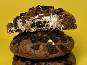Stack of chocolate cookies with Oreo pieces and melted cream inside.