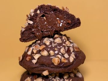 Chocolate cookies topped with chopped nuts and gooey melted chocolate inside.