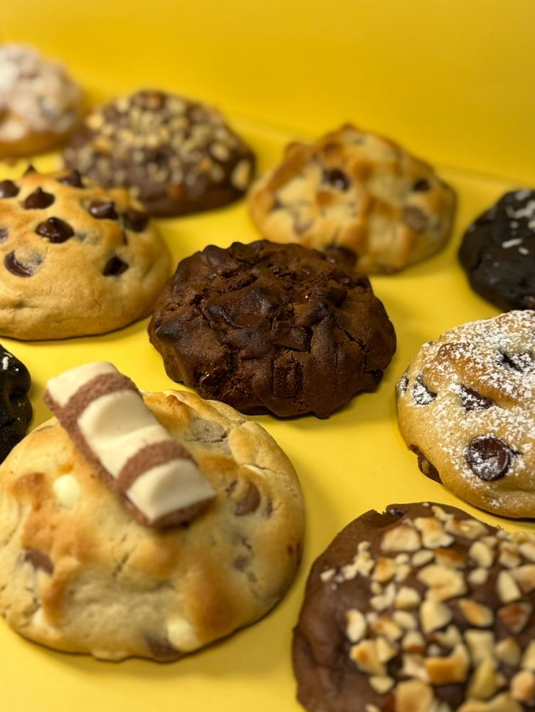 Assorted delicious cookies on a bright yellow surface.