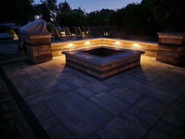 To warm for a fire, add outdoor hardscape lighting to your seating area and extend your nights.