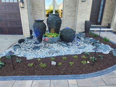 Decorative Water Feature with Aquascape's Stacked Slate Sphere and Urns with a Spillover Bowl. 