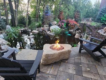 Backyard koi pond with fuax rock firepit and unilock Paver patio