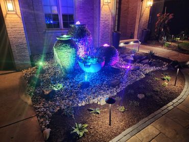 An evening water feature with subtle lighting in the front yard can be a captivating focal point.