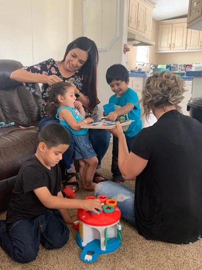 Family working with therapist and smiling and playing 