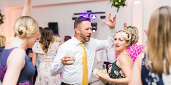 People dancing and enjoying drinks at a party.