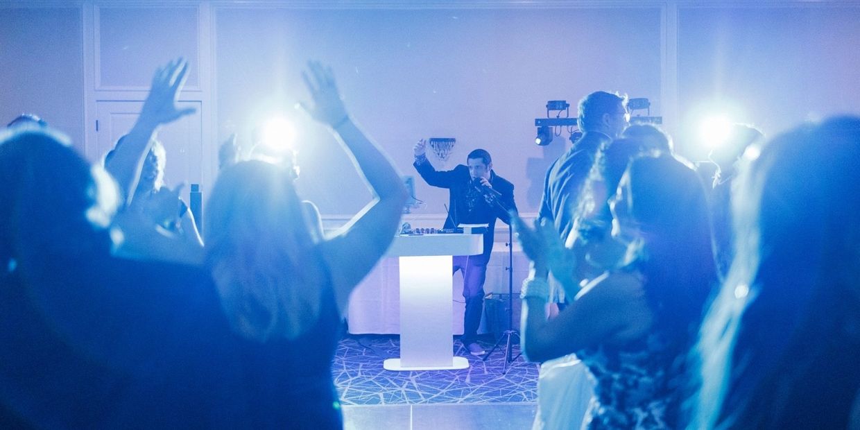 People dancing and enjoying a DJ performance.