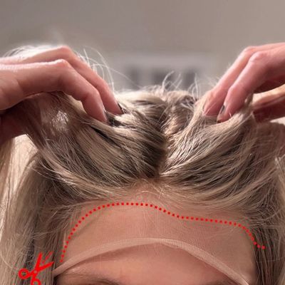 Hands lifting hair to show a lace front wig's lace edge for cutting.