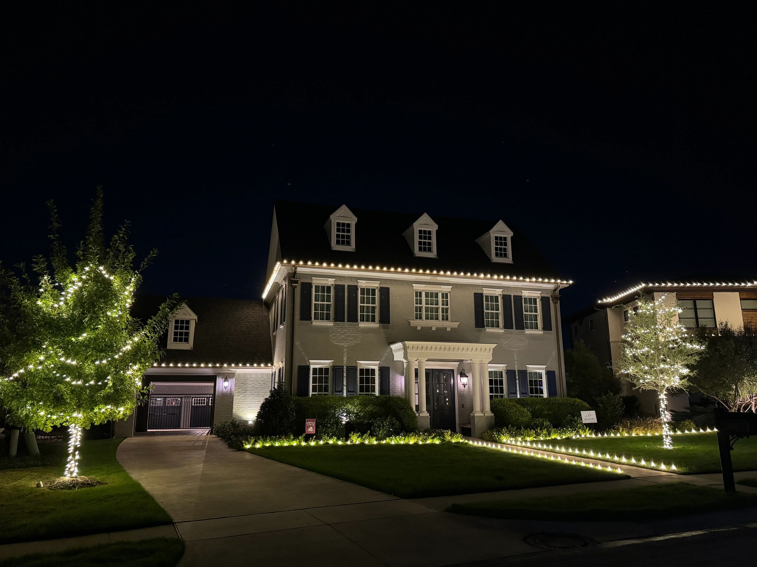 Elegant house illuminated with string lights at night.