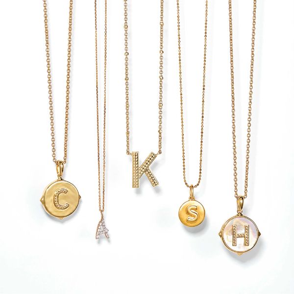Gold initial letter necklaces with elegant designs.