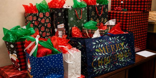 Christmas gift bags and wrapped presents on a table.