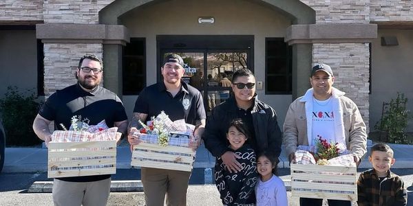 Group of people holding baskets of gifts outside a building.