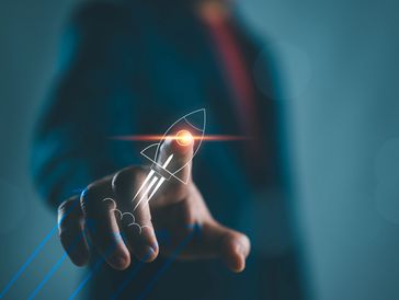 Person interacts with a glowing rocket icon symbolizing innovation and growth.