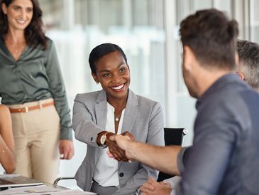 Two professionals shaking hands during a business meeting.