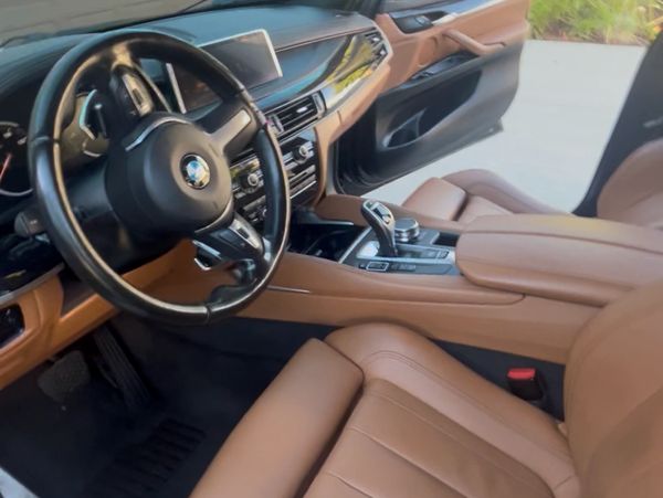 Luxurious BMW car interior with tan leather seats and modern dashboard.