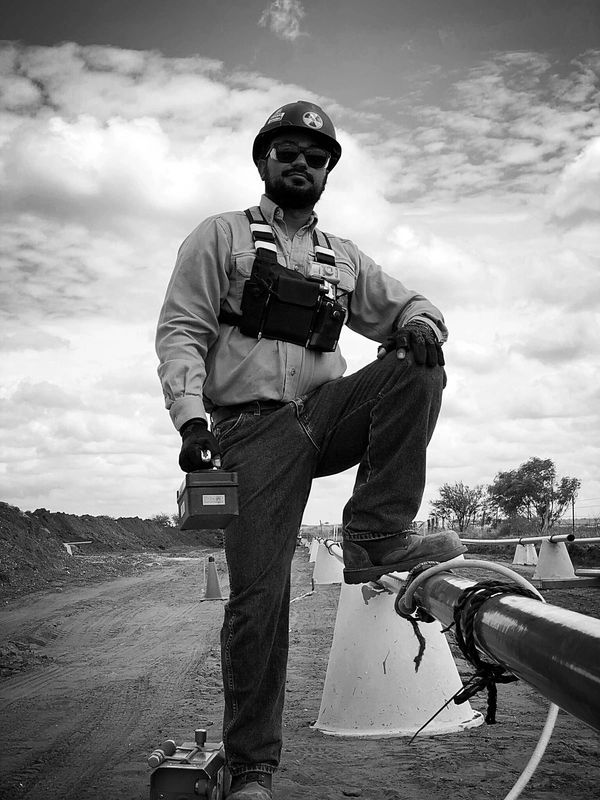 Construction worker in safety gear posing confidently on site.